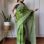 Green Cotton MulMul Jaipuri Printed Saree with elegant traditional prints, lightweight breathable fabric, and matching blouse piece for a graceful ethnic look.