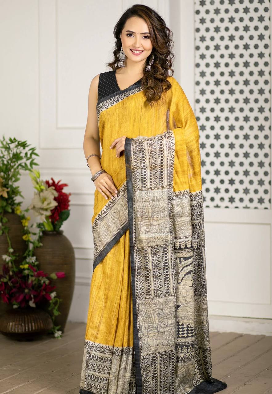 Mustard Yellow Linen Cotton Madhubani Print Saree Mustard Yellow Linen Cotton Madhubani Print Saree with traditional black and beige ethnic motifs, artistic printed pallu and border, matching black blouse fabric, festive wear saree for women.