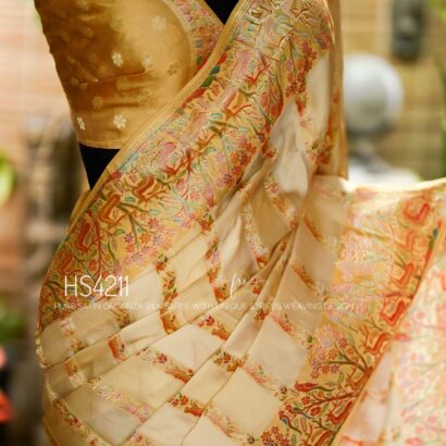 Cream Multicolor Satin Organza Silk Saree with sunset stripe pattern, rangkat dyeing, brocade border, woven buties and elegant pastel gradient design.