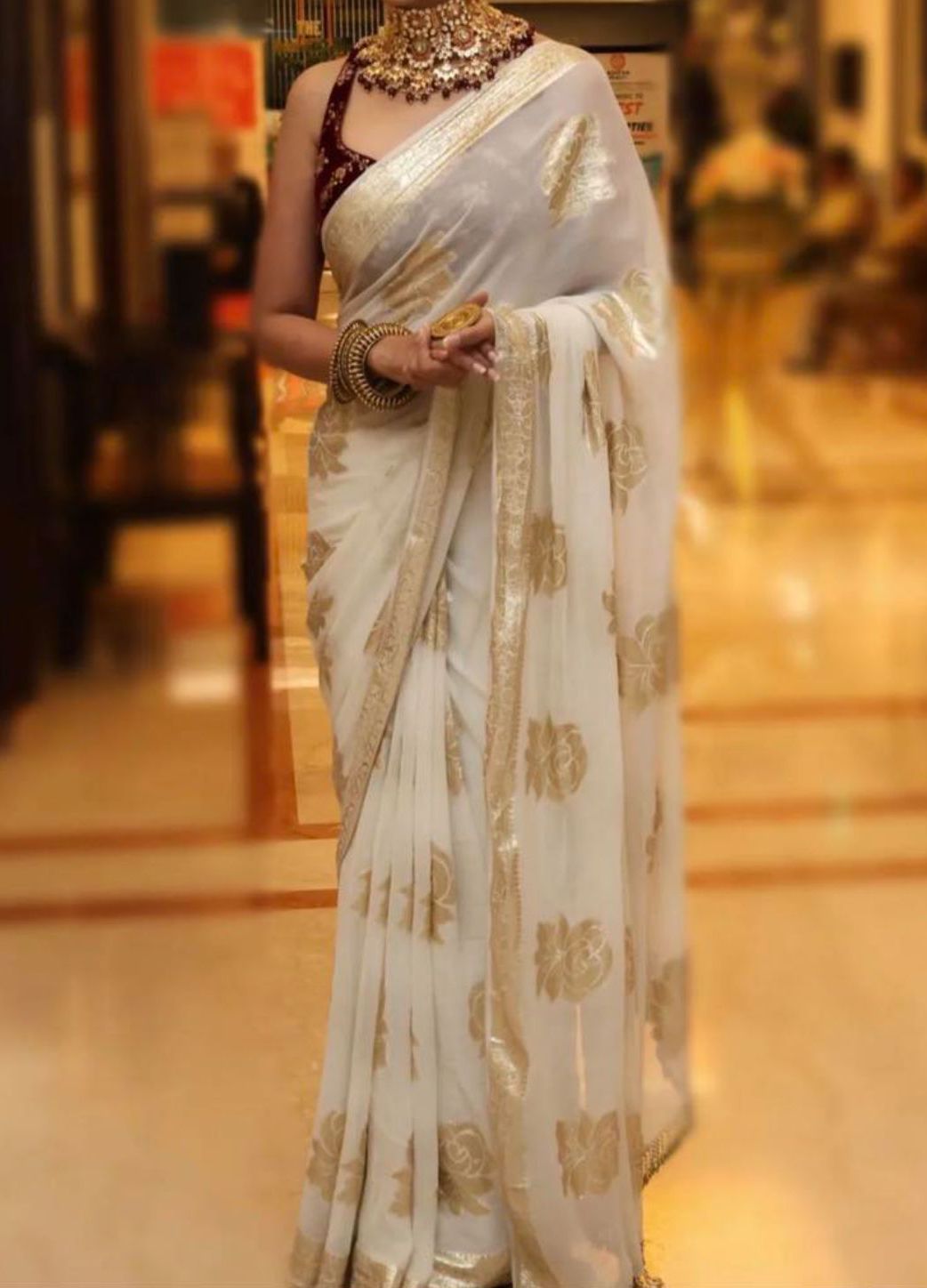 Cream Beige Gold Viscose Georgette Saree with Contrast Blouse Viscose Georgette Saree with Contrast Blouse in White Gold shade featuring floral zari motifs and elegant woven border.