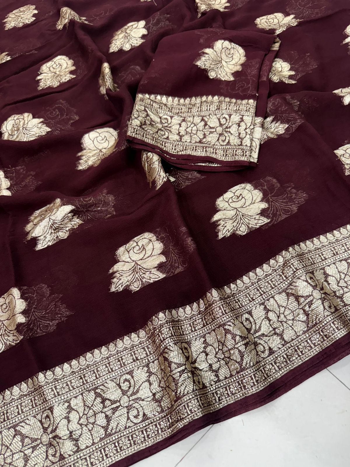 Viscose Georgette Saree with Contrast Blouse in Wine Maroon Gold shade featuring floral zari motifs and elegant woven border.