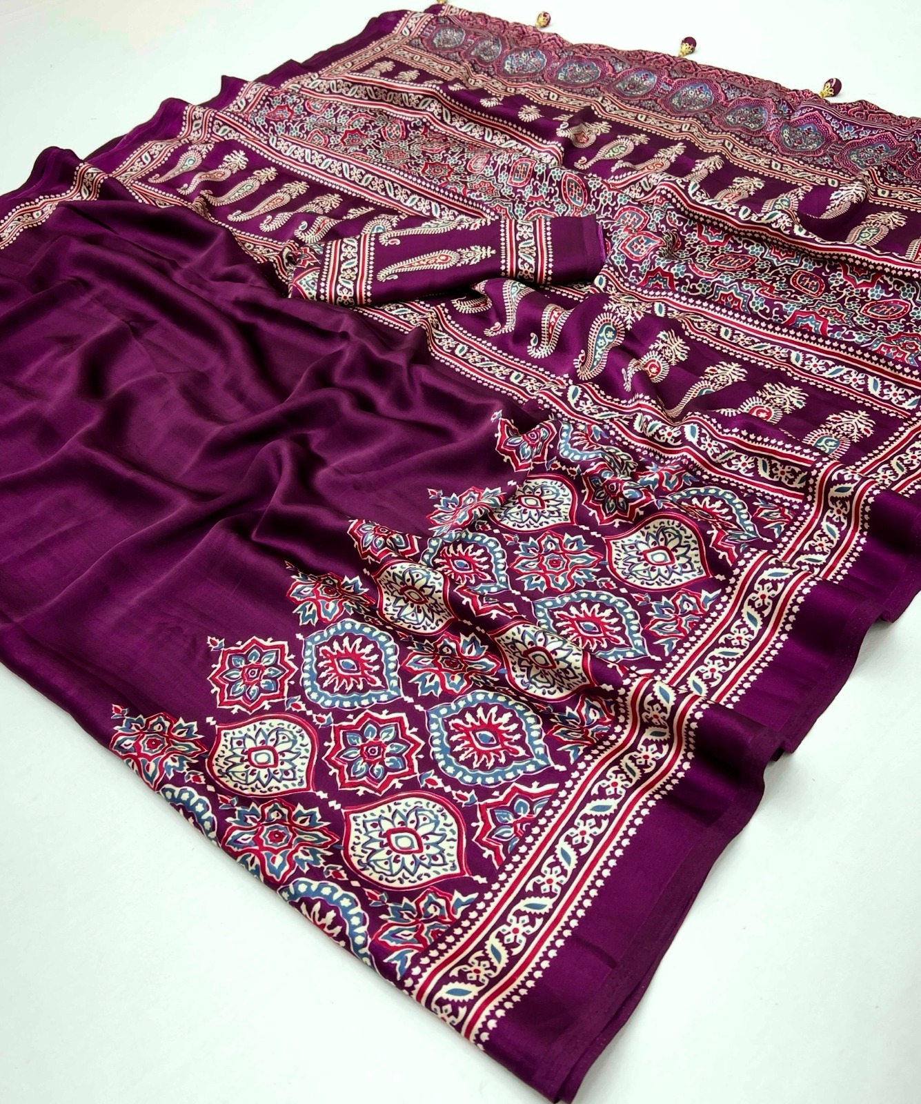 Ajrakh Satin Silk Saree in premium Modal Satin Silk with elegant digital print, tassels on pallu, 6.3 meter saree with matching blouse piece for festive and party wear.