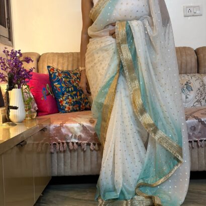 White & Sky Blue Fendi Satin Silk Saree with self-weaving jacquard, elegant buttis, ombre design, fancy golden jhalar lace border, and matching running blouse for festive, party, and wedding wear.