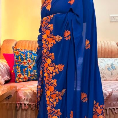 Blue Kashmiri silk saree with intricate handcrafted Aari Resham border embroidery and matching blouse piece.