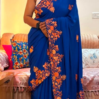 Blue Kashmiri silk saree with intricate handcrafted Aari Resham border embroidery and matching blouse piece.