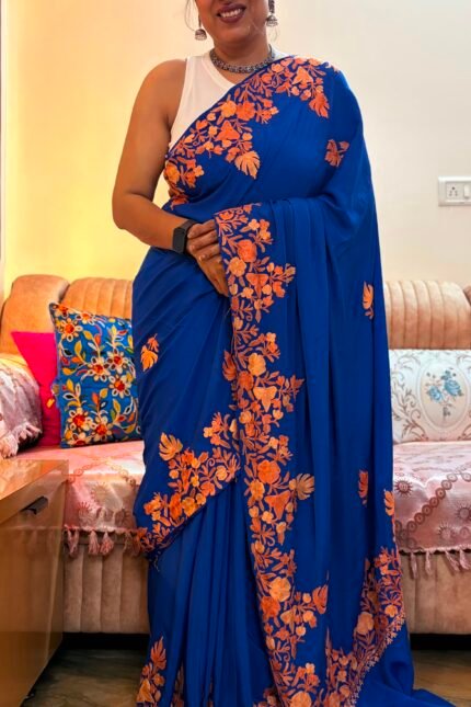 Blue Kashmiri silk saree with intricate handcrafted Aari Resham border embroidery and matching blouse piece.